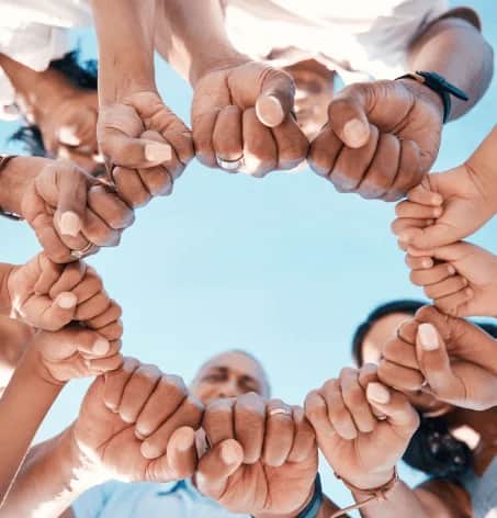 Fists joined in a circle, symbolising unity and teamwork